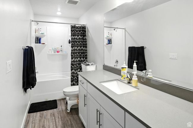 Full private bath featuring wood-style LVP floors, vanity, and shower / bath combination with curtain | Image 12
