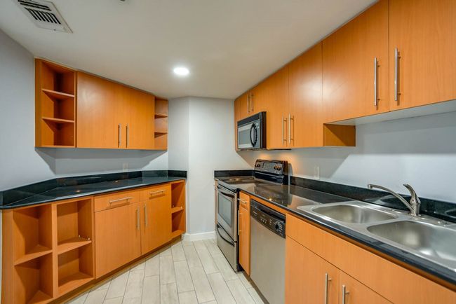 Kitchen with open shelves, appliances with stainless steel finishes, dark countertops, and recessed lighting | Image 5