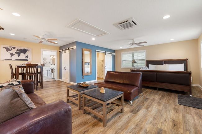 Living room with a ceiling fan, baseboards, light wood-style floors, a barn door, and recessed lighting | Image 24