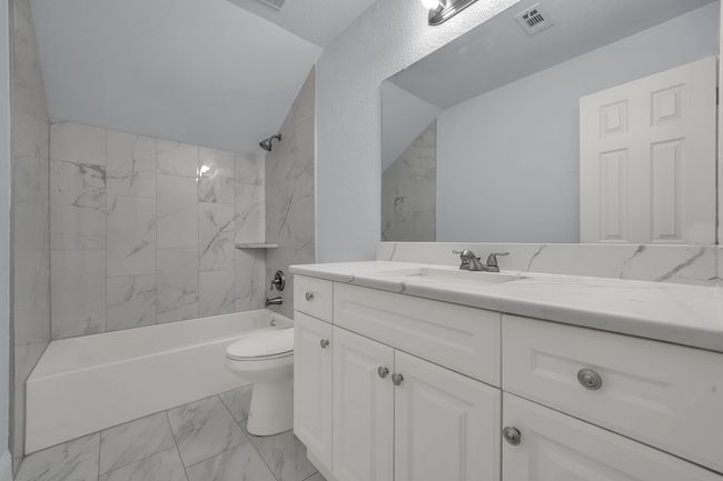 Full bathroom featuring marble look tiles, vanity, and bathing tub / shower combination | Image 19