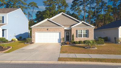 View of front of house featuring a garage and a front lawn | Image 1