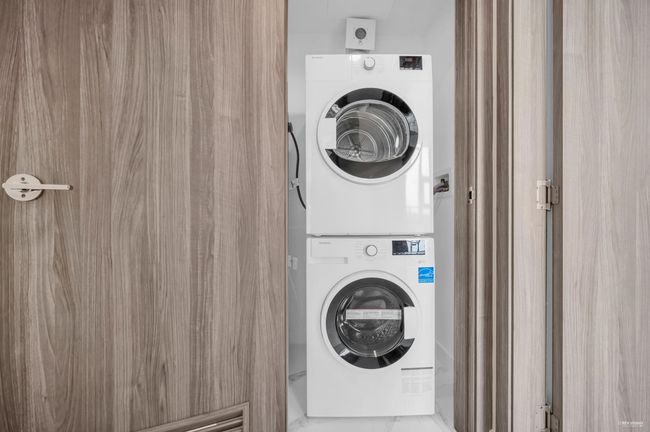 Laundry area with stacked washer and clothes dryer | Image 18