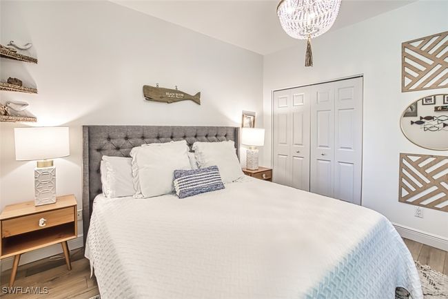 Bedroom featuring light wood-style floors, a chandelier, and a closet | Image 39