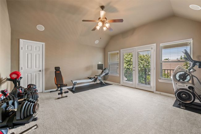 Exercise room with vaulted ceiling, a ceiling fan, and carpet flooring | Image 27