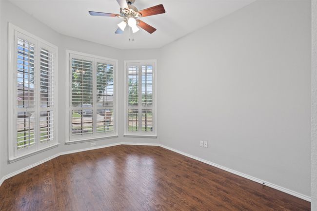 Unfurnished room featuring a ceiling fan and dark wood-style flooring | Image 7