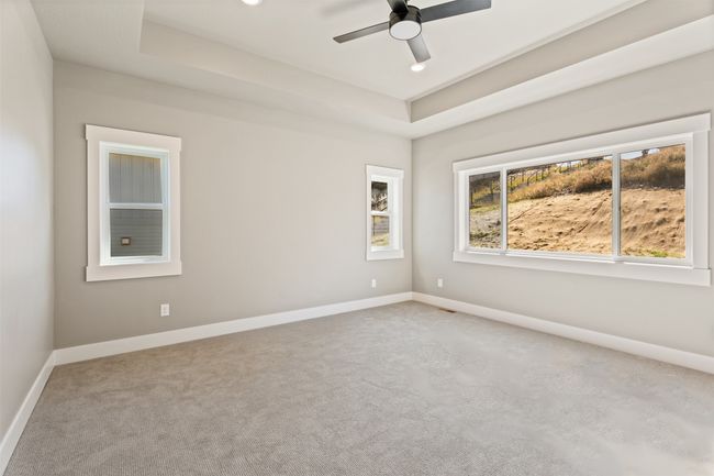 Carpeted spare room featuring a tray ceiling, a ceiling fan, and baseboards | Image 20