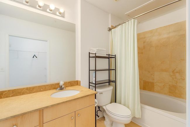Bathroom featuring vanity, shower / tub combo with curtain, and a walk in closet | Image 13