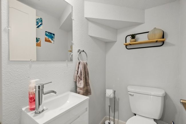 Half bathroom featuring toilet and vanity downstairs | Image 18