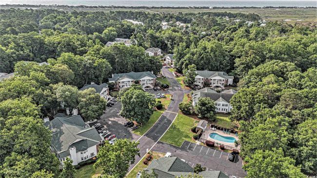 Aerial overview of property's location with a heavily wooded area, a pool, and nearby suburban area | Image 29