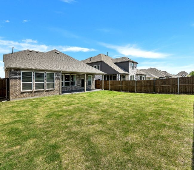 Back of house with brick siding, a yard, a patio area, and a fenced backyard | Image 29