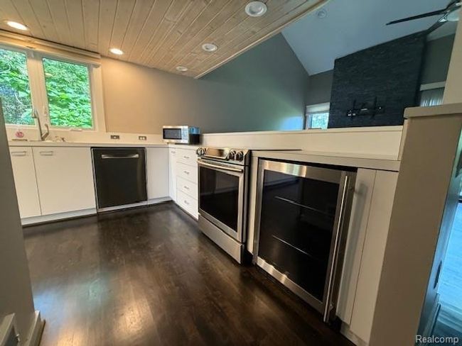 Kitchen with white cabinetry, wine cooler, stainless steel appliances, recessed lighting, and dark wood-type flooring | Image 4