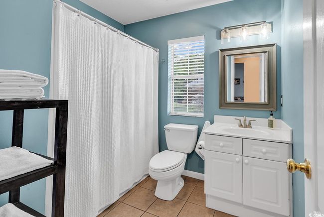 Full bath with tile patterned floors, vanity, and curtained shower | Image 7