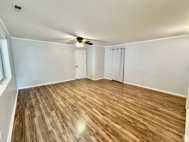 Empty room with visible vents, baseboards, wood finished floors, and ceiling fan | Image 26
