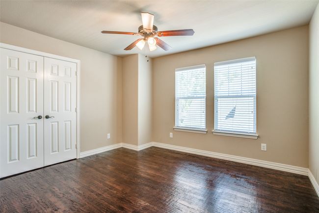 Unfurnished bedroom with dark wood-style floors, baseboards, a closet, and ceiling fan | Image 9