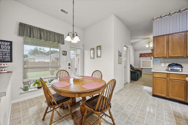 Dining space featuring a ceiling fan and a chandelier | Image 21