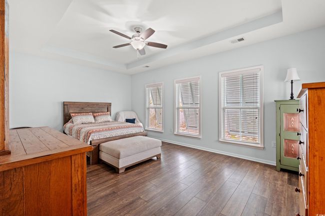 Master bedroom on the second level with a walk in closet, master bathroom, large windows, tray ceiling and a deck off of the bedroom overlooking the front. | Image 12