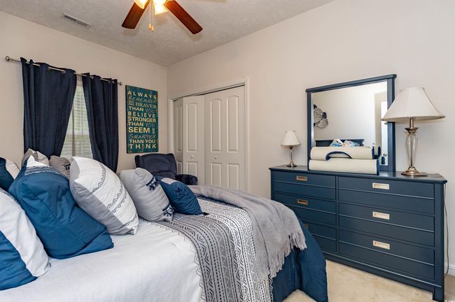 Bedroom with visible vents, light carpet, a closet, a textured ceiling, and ceiling fan | Image 21