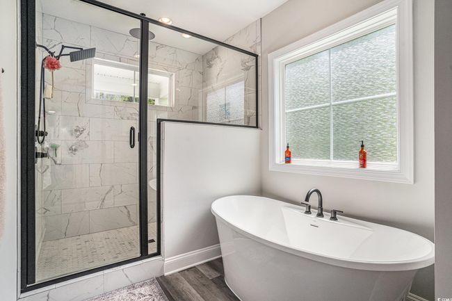 Full bathroom with a soaking tub, a stall shower, and plenty of natural light | Image 26