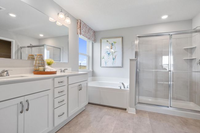 Primary bath with dual sinks, soaking tub, and separate shower. Model photo. Options and colors will vary. | Image 20