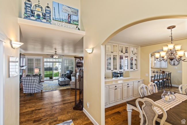 Dining area with dark hardwood / wood-style floors, ornamental molding, and ceiling fan with notable chandelier | Image 18