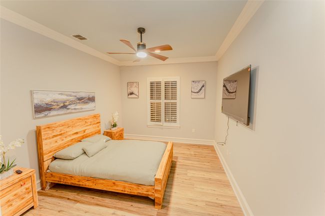 Bedroom featuring crown molding, light wood-style flooring, and a ceiling fan | Image 30