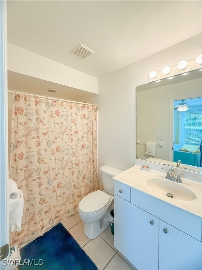 Bathroom featuring toilet, tile patterned floors, vanity, visible vents, and a shower with curtain | Image 41