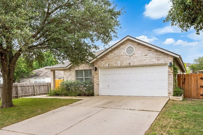 View of front of home with brick siding, an attached garage, and concrete driveway | Image 4
