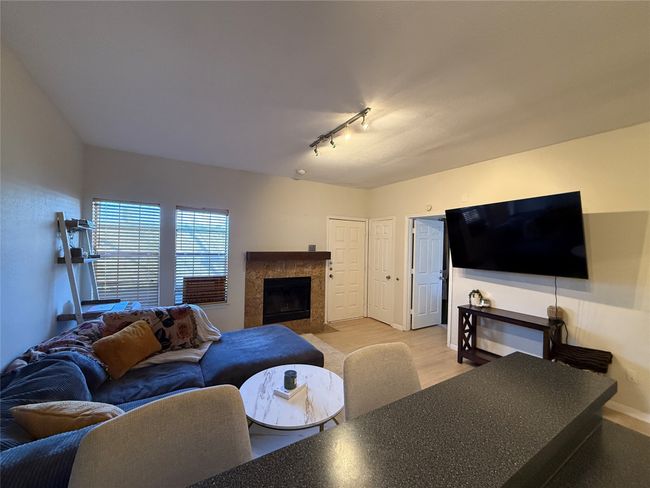 Living area featuring a high end fireplace, baseboards, track lighting, and wood finished floors | Image 9