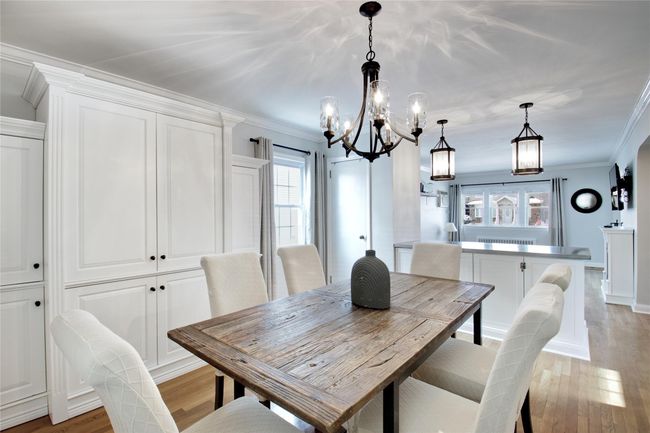 Dining room with a chandelier, light wood finished floors, and crown molding | Image 6
