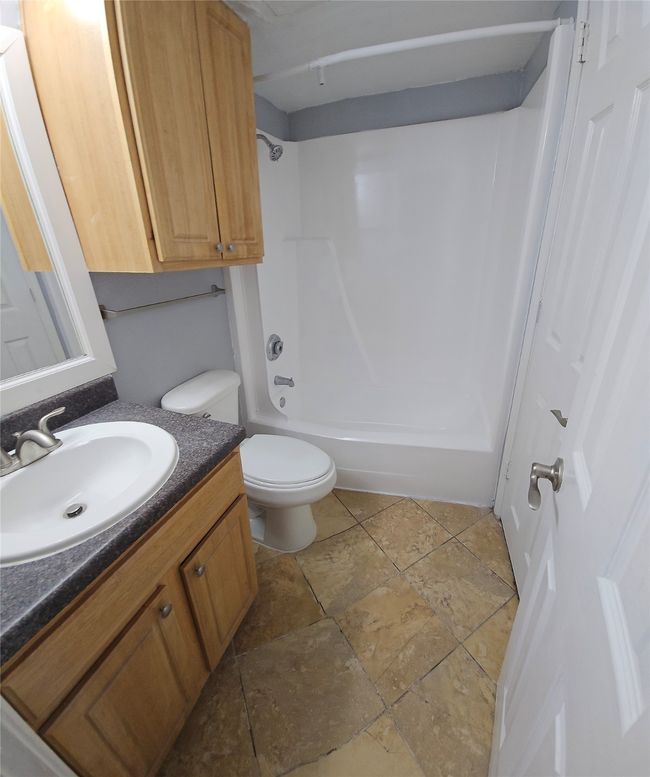 Bathroom with vanity, stone tile flooring, and shower combination | Image 19
