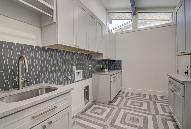 Laundry room with cabinet space, plenty of natural light, and baseboards | Image 21