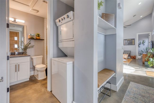 Laundry area featuring stacked washer / drying machine and baseboards | Image 13