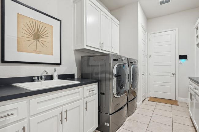 Washroom featuring separate washer and dryer, cabinet space, and light tile patterned flooring | Image 27