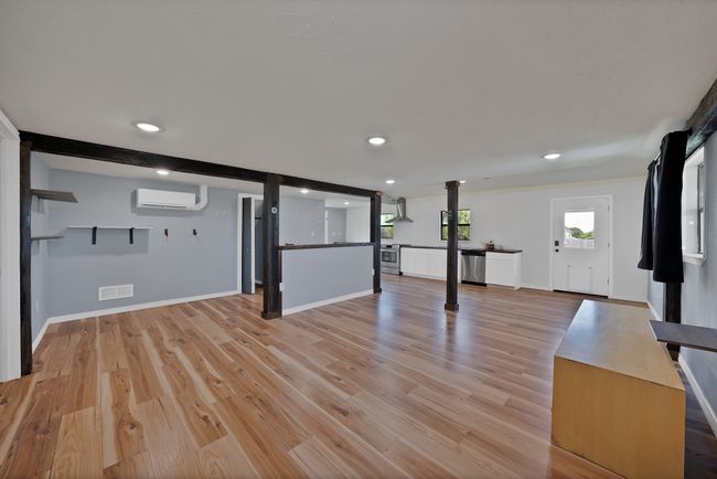 Unfurnished living room with a wall unit AC, light wood-style flooring, and recessed lighting | Image 5