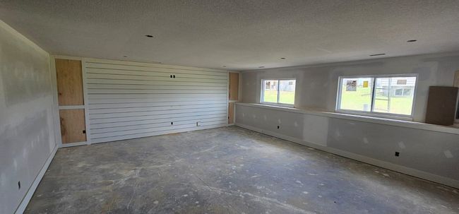 Unfurnished room with unfinished concrete floors and a textured ceiling | Image 12