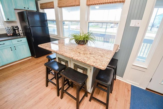 This kitchen features a rolling breakfast island and seating for 6. | Image 9
