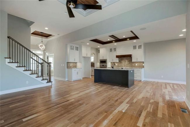 Kitchen featuring open floor plan, light wood-type flooring, tasteful backsplash, and recessed lighting | Image 7
