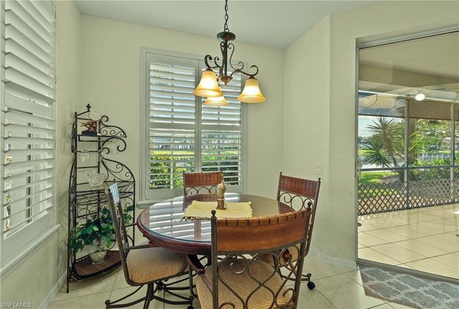 Dining space featuring light tile patterned floors and a notable chandelier | Image 7