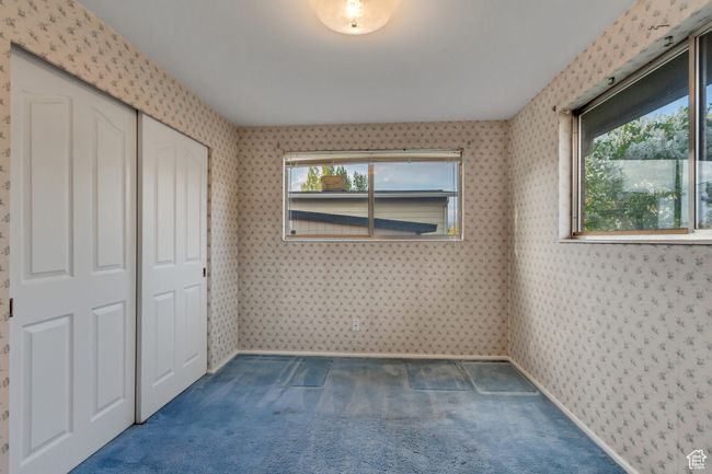Unfurnished bedroom featuring wallpapered walls, carpet, and a closet | Image 15