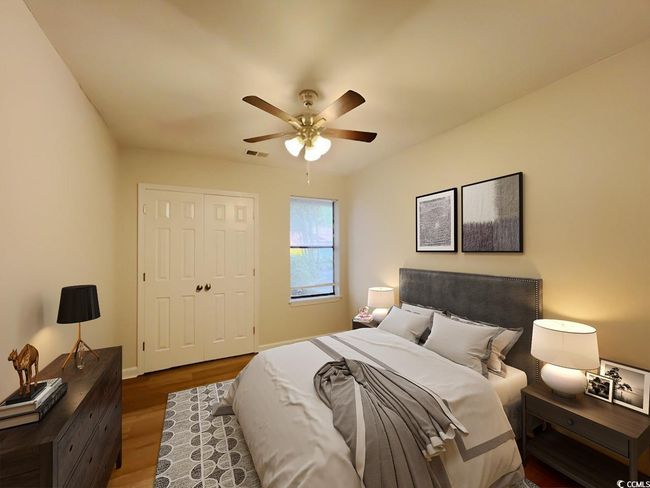 Bedroom with a closet, baseboards, wood finished floors, and a ceiling fan | Image 16