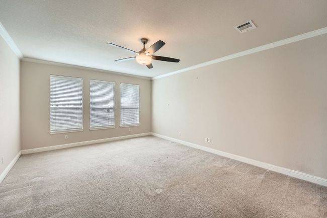 Spare room with visible vents, ornamental molding, light carpet, baseboards, and ceiling fan | Image 19