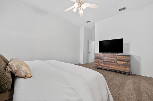 Carpeted bedroom featuring ceiling fan and vaulted ceiling | Image 18