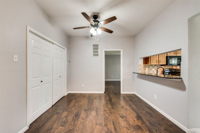 Unfurnished living room featuring a ceiling fan and dark wood-style floors | Image 4