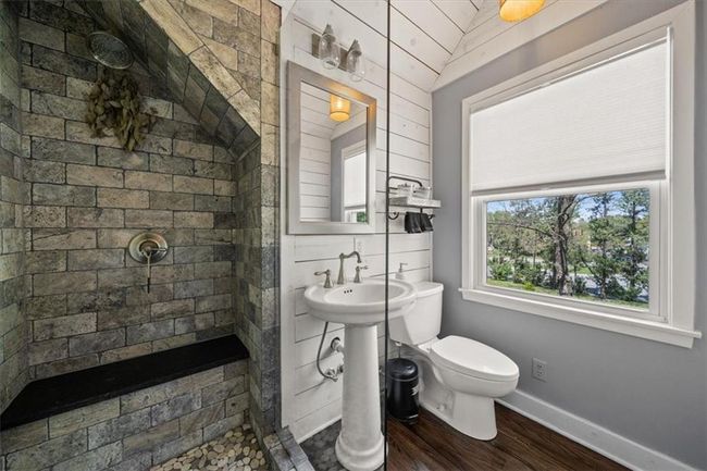 Primary on suite Bathroom featuring toilet, a tile shower, wood finished floors, and baseboards | Image 17