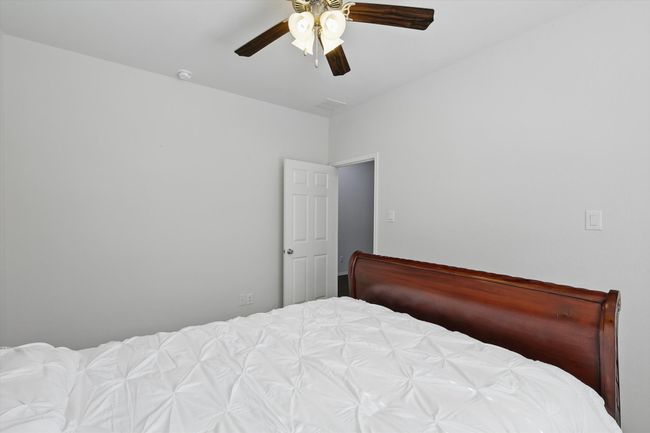 Bedroom with a ceiling fan and visible vents | Image 10