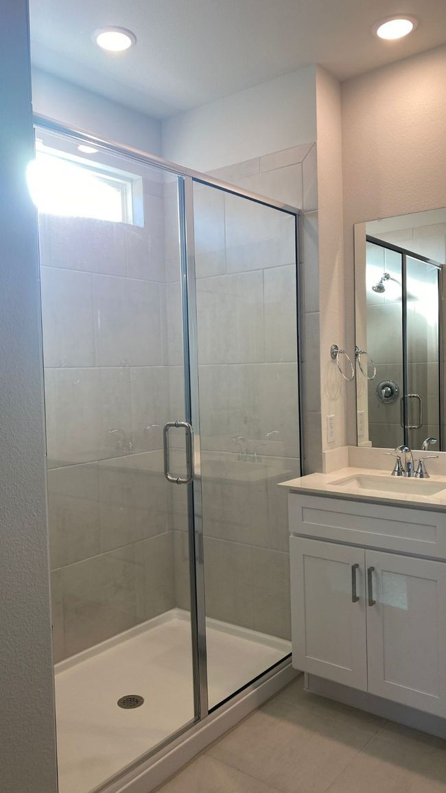 Bathroom with vanity, a shower stall, tile patterned flooring, and recessed lighting | Image 15