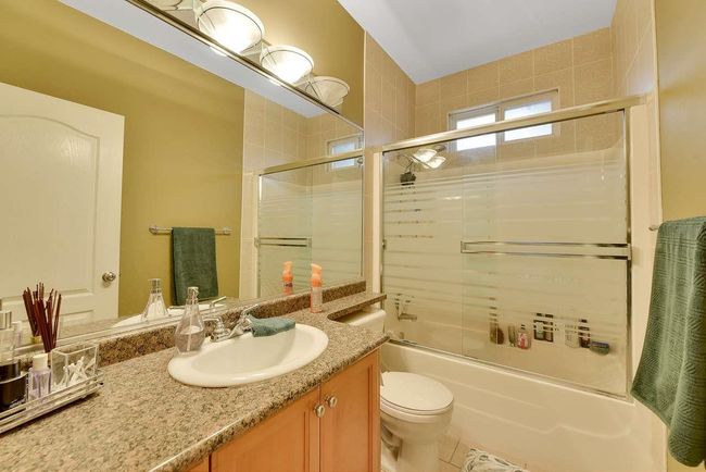 Bathroom with vanity, shower / bath combination with glass door, and toilet | Image 36