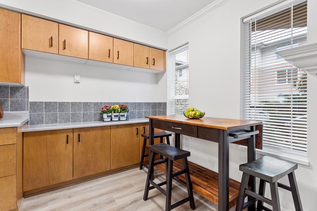 Kitchen with light countertops, crown molding, tasteful backsplash, and light wood finished floors | Image 16