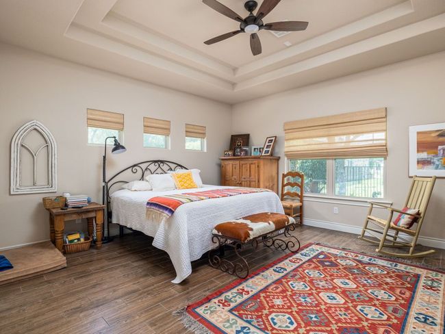 Master Bedroom with double tray ceiling and panoramic views of the lush backyard. | Image 13