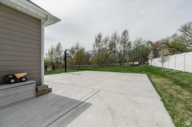 View of sport court with basketball court, a yard, and fence | Image 65